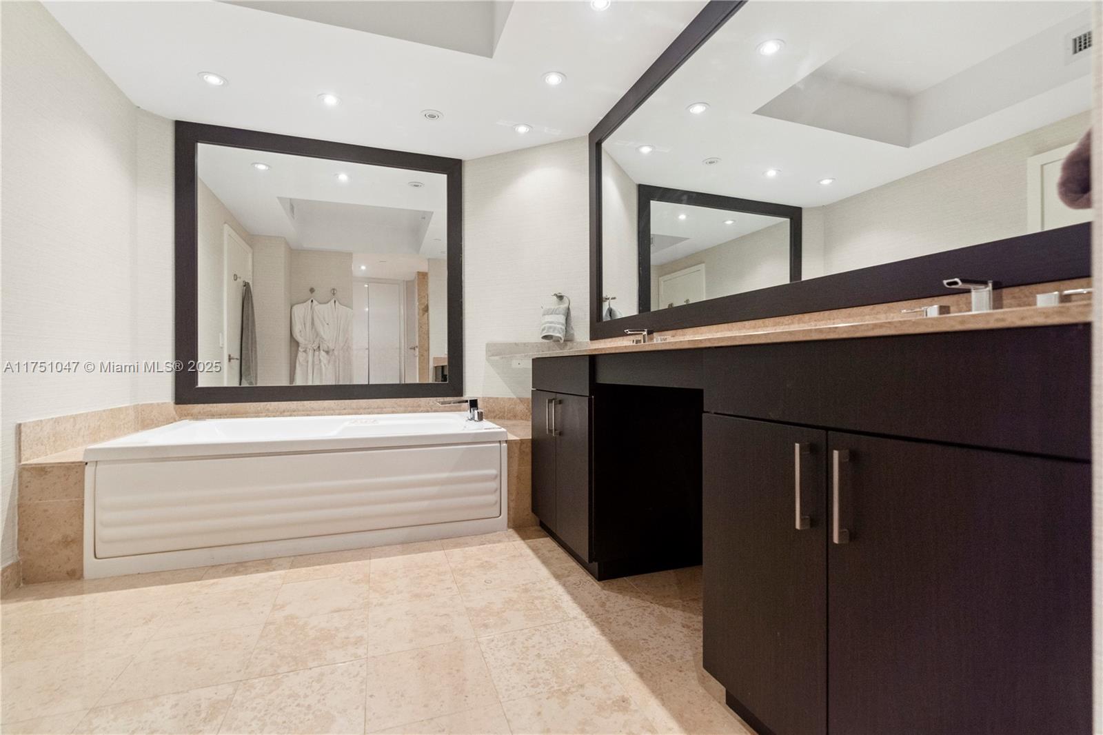 4779 Collins Avenue, Unit 2204 Miami Beach, FL 33140 - Photo 26 of 58 a bathroom with a bathtub and a vanity