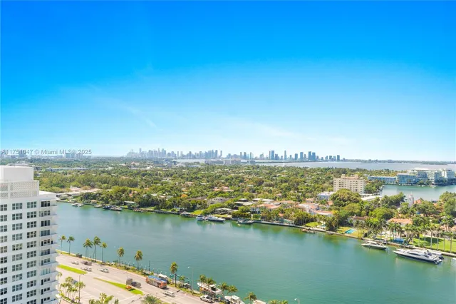 an aerial view of ocean and residential houses with outdoor space