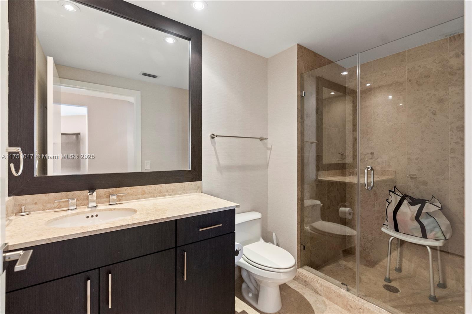 4779 Collins Avenue, Unit 2204 Miami Beach, FL 33140 - Photo 32 of 58 a bathroom with a sink toilet a mirror and shower