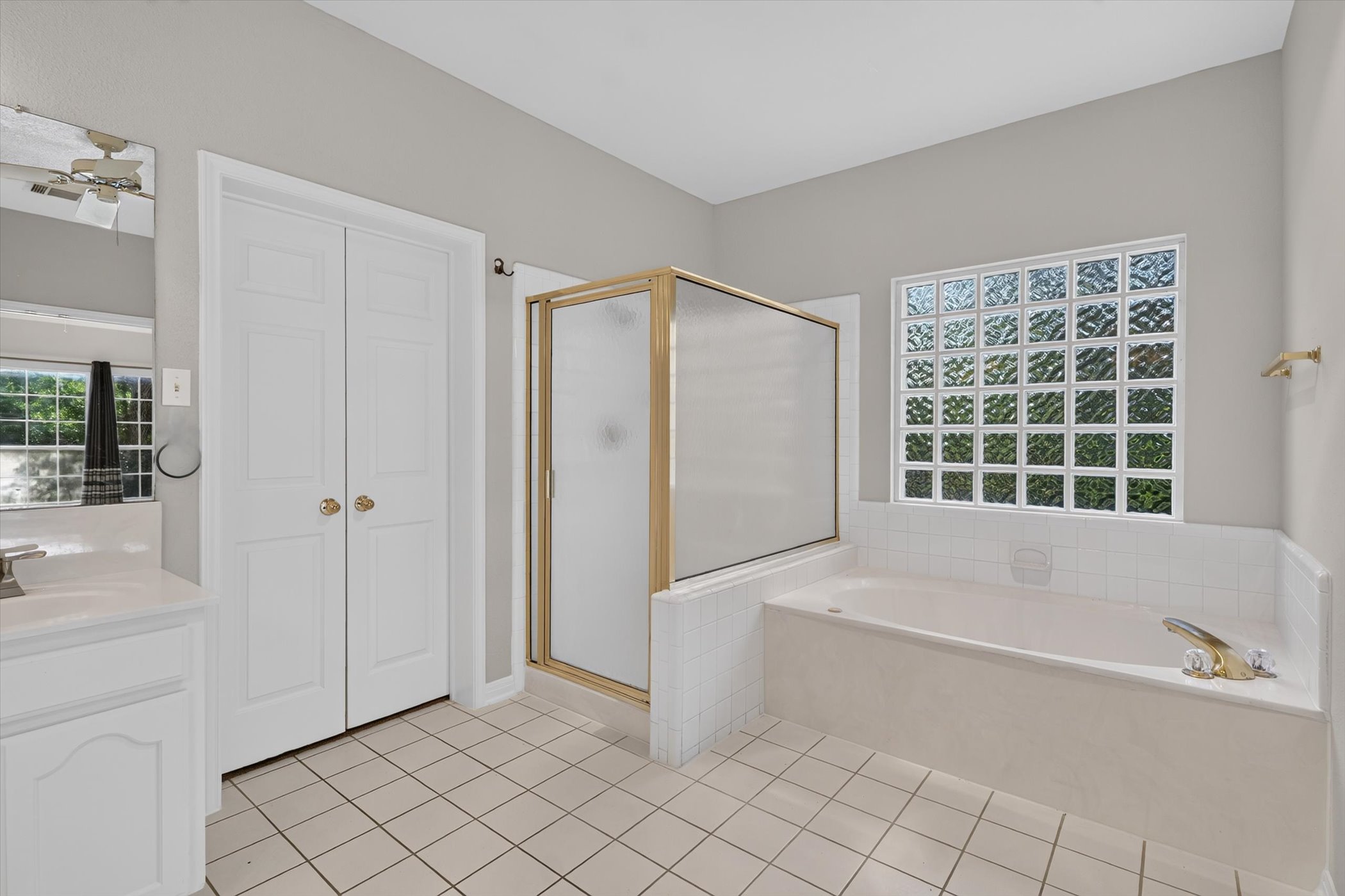 13615 Copperleaf Trail Manchaca, TX 78652 - Photo 23 of 38 A pristine primary bathroom features a generous soaking tub, a separate shower, and a private glass block window.