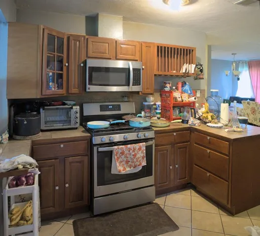 a kitchen with stainless steel appliances granite countertop a stove microwave and cabinets