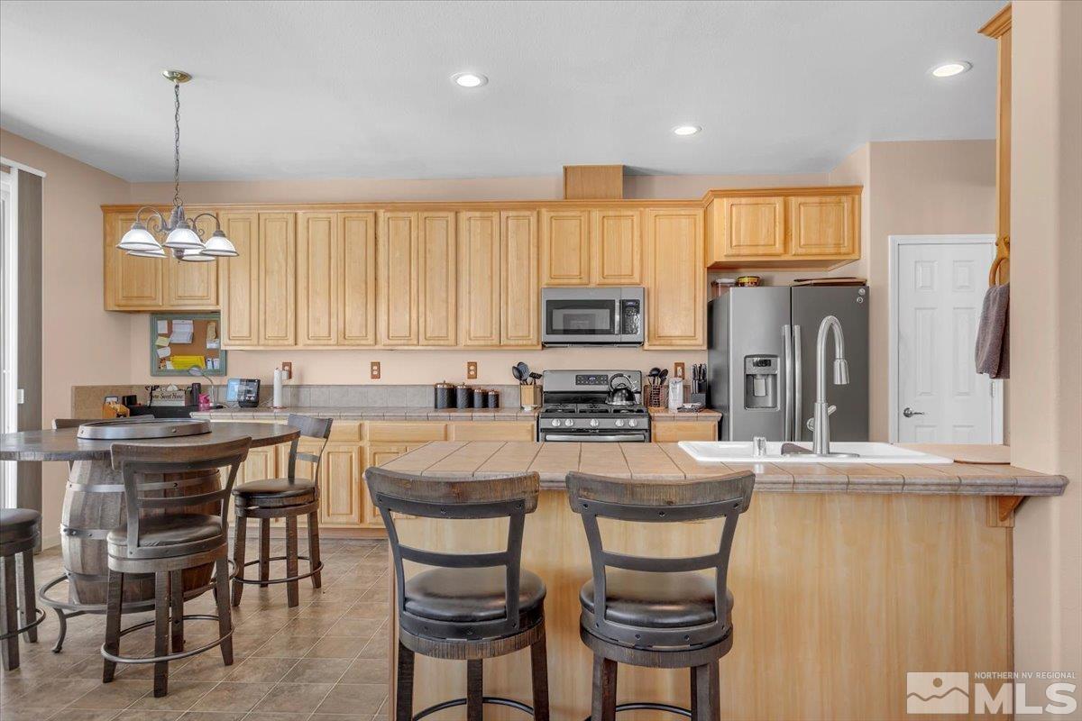 5670 Falcon Ridge Court Sparks, NV 89436 - Photo 12 of 40 a kitchen with stainless steel appliances granite countertop a stove a sink a microwave a refrigerator and cabinets