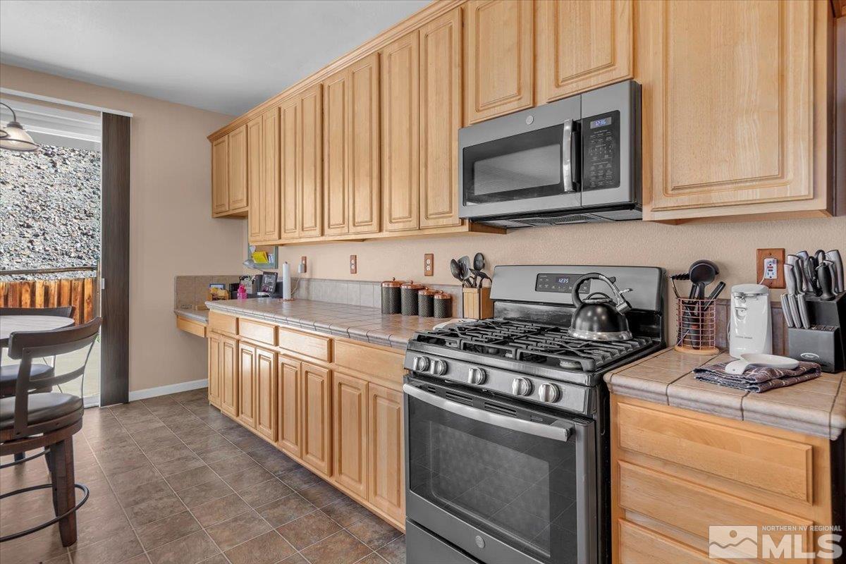 5670 Falcon Ridge Court Sparks, NV 89436 - Photo 14 of 40 a kitchen with stainless steel appliances granite countertop grey cabinets a stove a sink and dishwasher