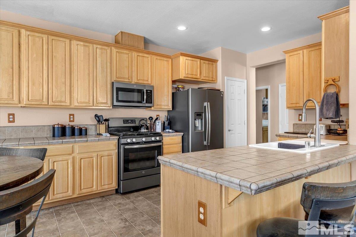 5670 Falcon Ridge Court Sparks, NV 89436 - Photo 15 of 40 a kitchen with a stove a sink and a refrigerator