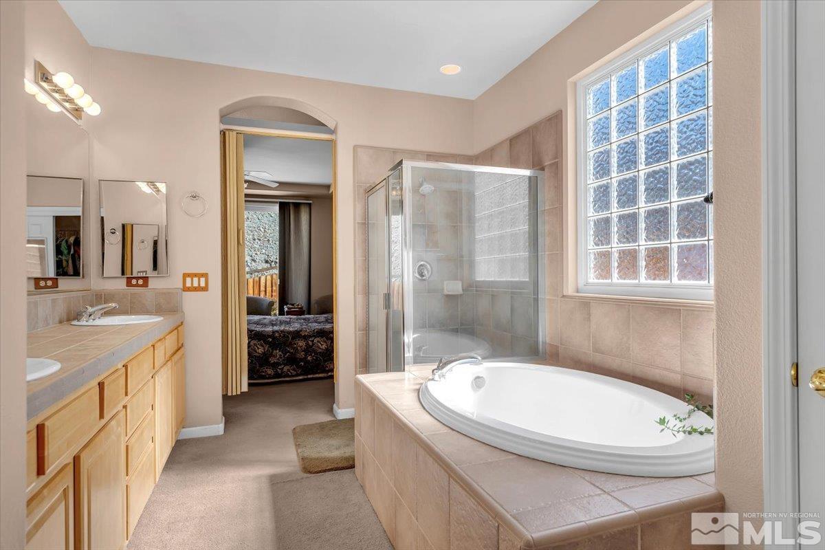5670 Falcon Ridge Court Sparks, NV 89436 - Photo 22 of 40 a bathroom with a granite countertop sink a toilet a mirror and shower