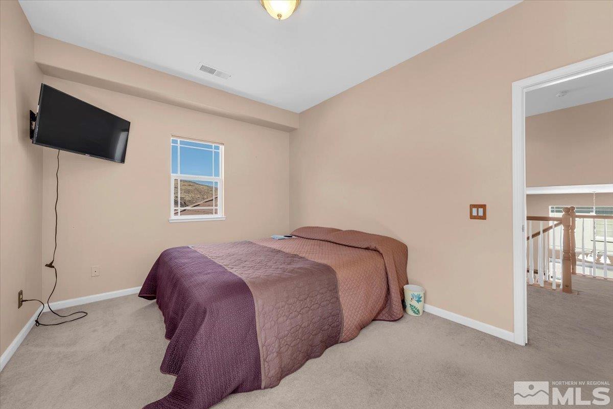5670 Falcon Ridge Court Sparks, NV 89436 - Photo 34 of 40 a bedroom with a bed a flat screen tv and a window