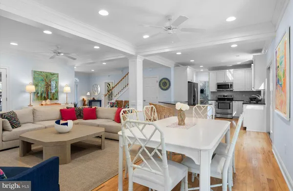 a living room with stainless steel appliances kitchen island granite countertop a dining table chairs stove and kitchen island