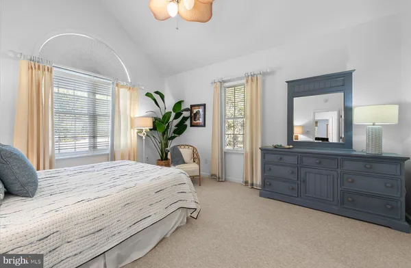 a bedroom with a large bed and dresser with mirror