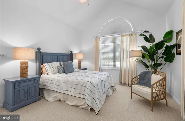 a bedroom with a bed table flowerpot and window