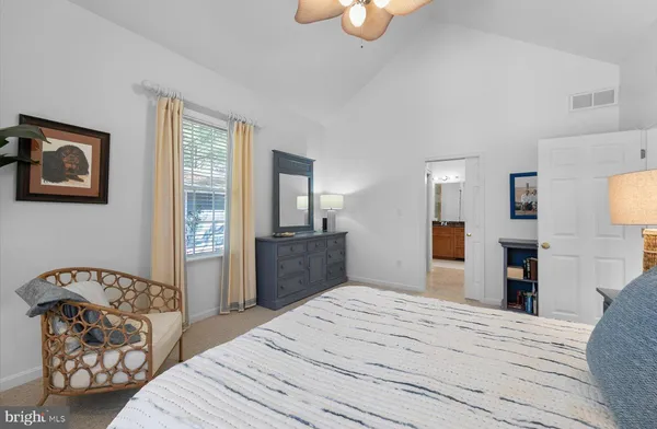 a bedroom with a bed and dresser with mirror