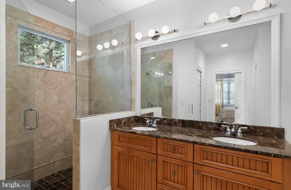 a bathroom with a granite countertop sink a mirror and a shower