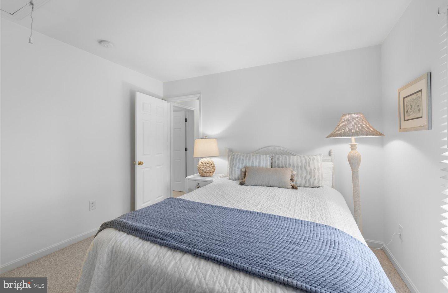 21 Cedar Road Rehoboth Beach, DE 19971 - Photo 38 of 59 a bedroom with a bed and a lamp