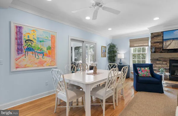 a view of a dining room with furniture a fireplace and wooden floor