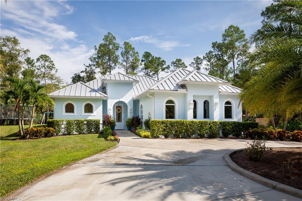 421 35th Avenue Northeast Naples, FL 34120 - Photo 1 of 39 a front view of a house with a garden