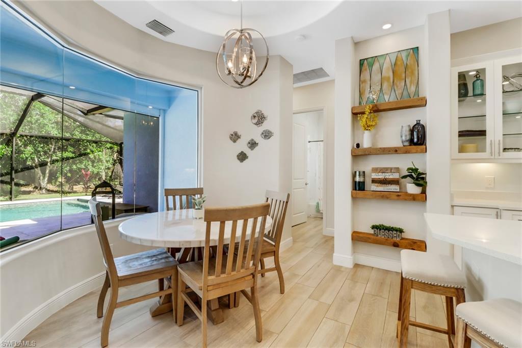 421 35th Avenue Northeast Naples, FL 34120 - Photo 14 of 39 a dining room with wooden floor and a chandelier