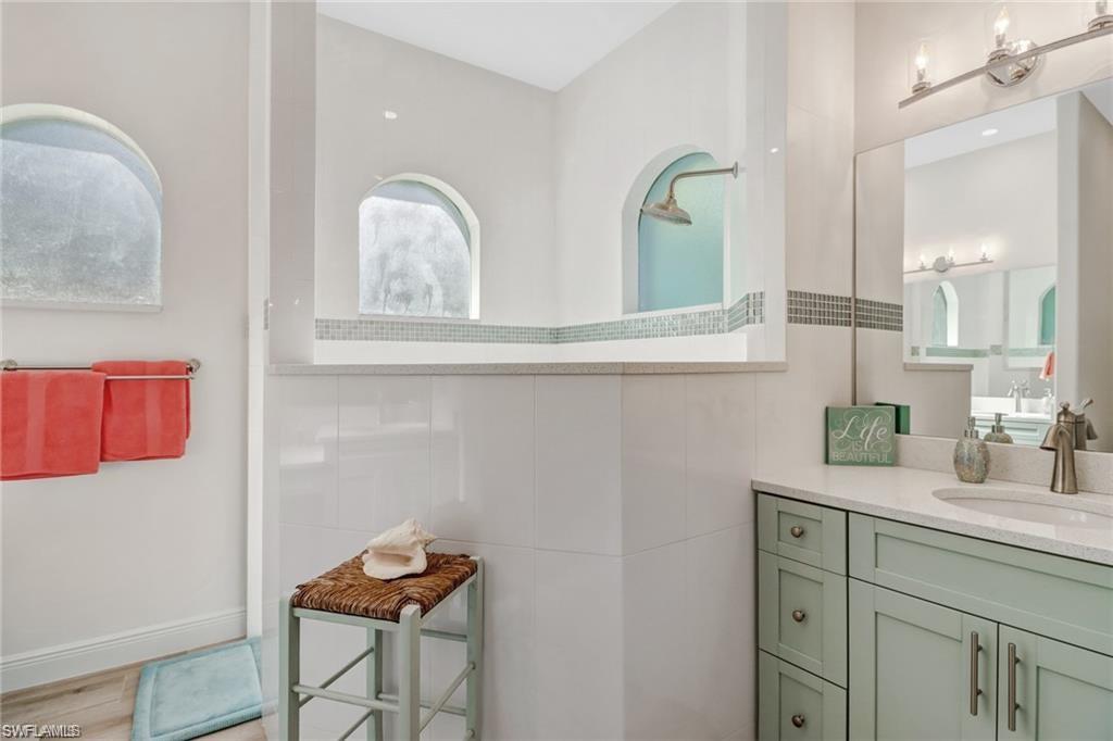 421 35th Avenue Northeast Naples, FL 34120 - Photo 21 of 39 a bathroom with a granite countertop sink and a mirror