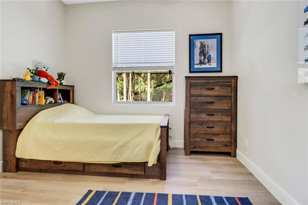 421 35th Avenue Northeast Naples, FL 34120 - Photo 24 of 39 a bed sitting in a bedroom next to a window