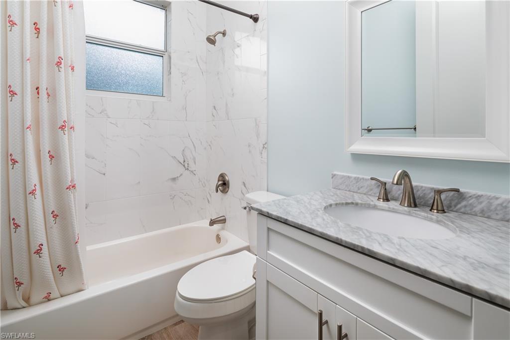 421 35th Avenue Northeast Naples, FL 34120 - Photo 27 of 39 a bathroom with a granite countertop sink toilet and shower