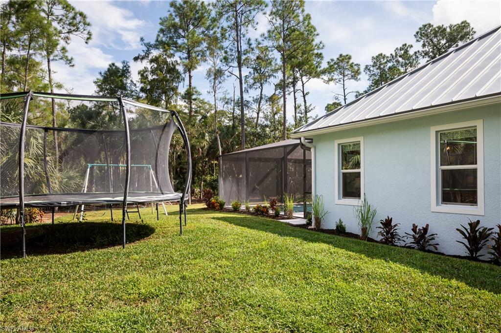 421 35th Avenue Northeast Naples, FL 34120 - Photo 32 of 39 a backyard of a house with table and chairs