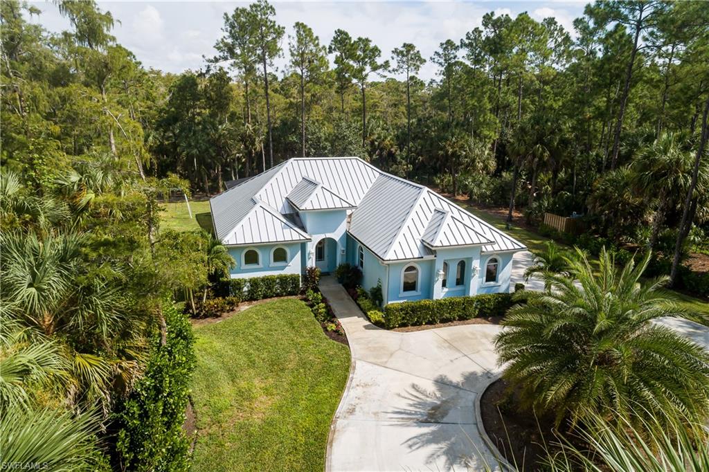 421 35th Avenue Northeast Naples, FL 34120 - Photo 35 of 39 a front view of a house with a garden