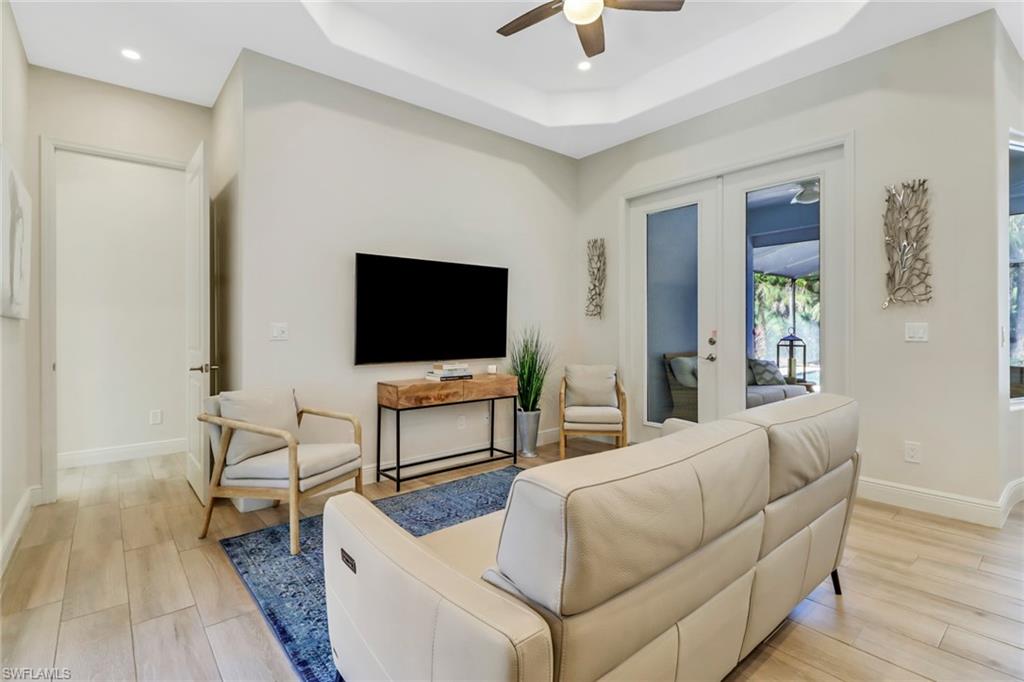 421 35th Avenue Northeast Naples, FL 34120 - Photo 5 of 39 a living room with furniture and a flat screen tv