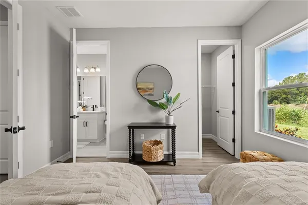 a bedroom with a bed a mirror and a window