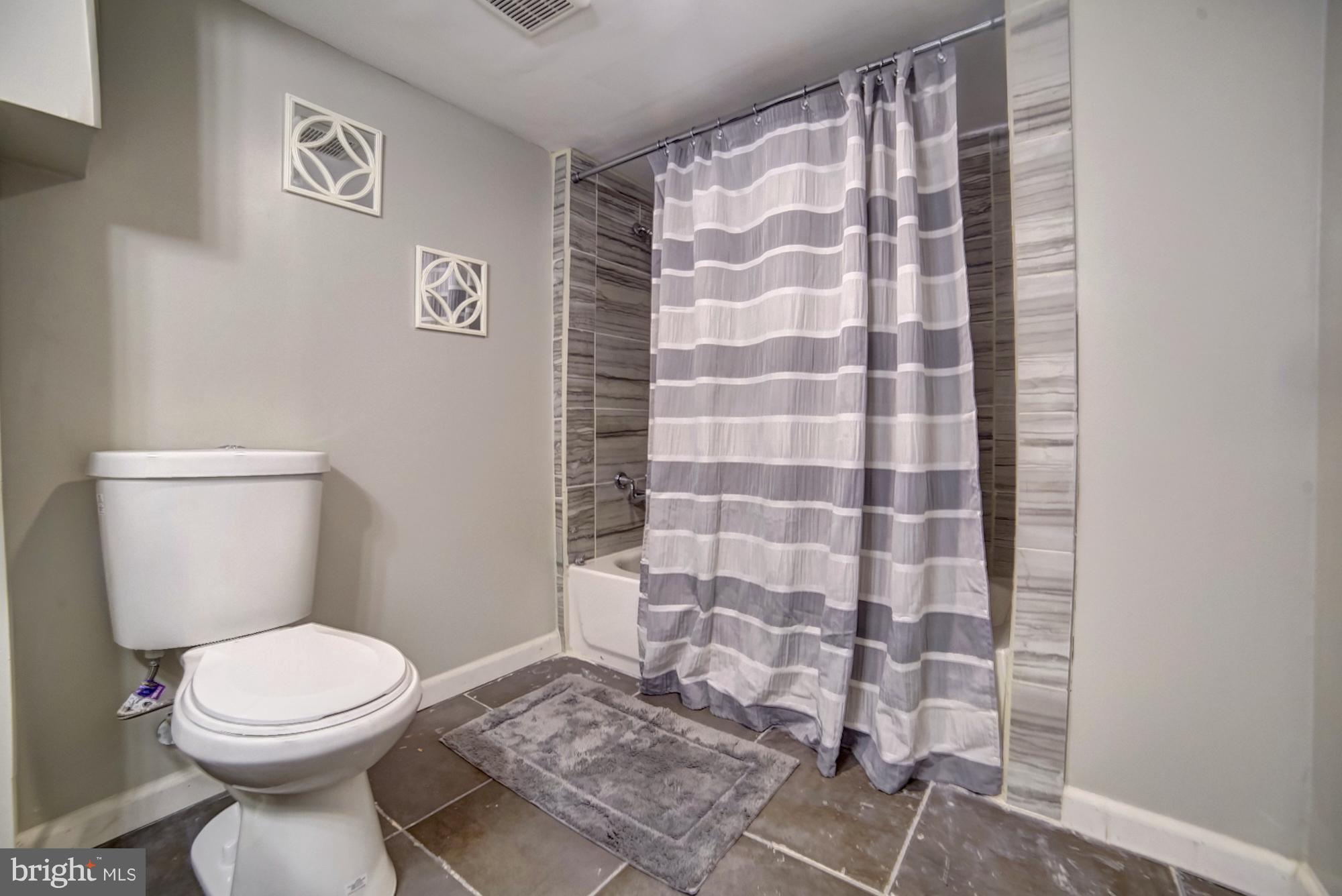 4008 Ridgecroft Road Baltimore, MD 21206 - Photo 16 of 17 a bathroom with a toilet and a shower curtain