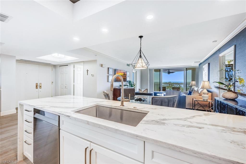 6849 Grenadier Boulevard, Unit 503 Naples, FL 34108 - Photo 12 of 50 a kitchen with stainless steel appliances kitchen island granite countertop a sink a counter space and cabinets