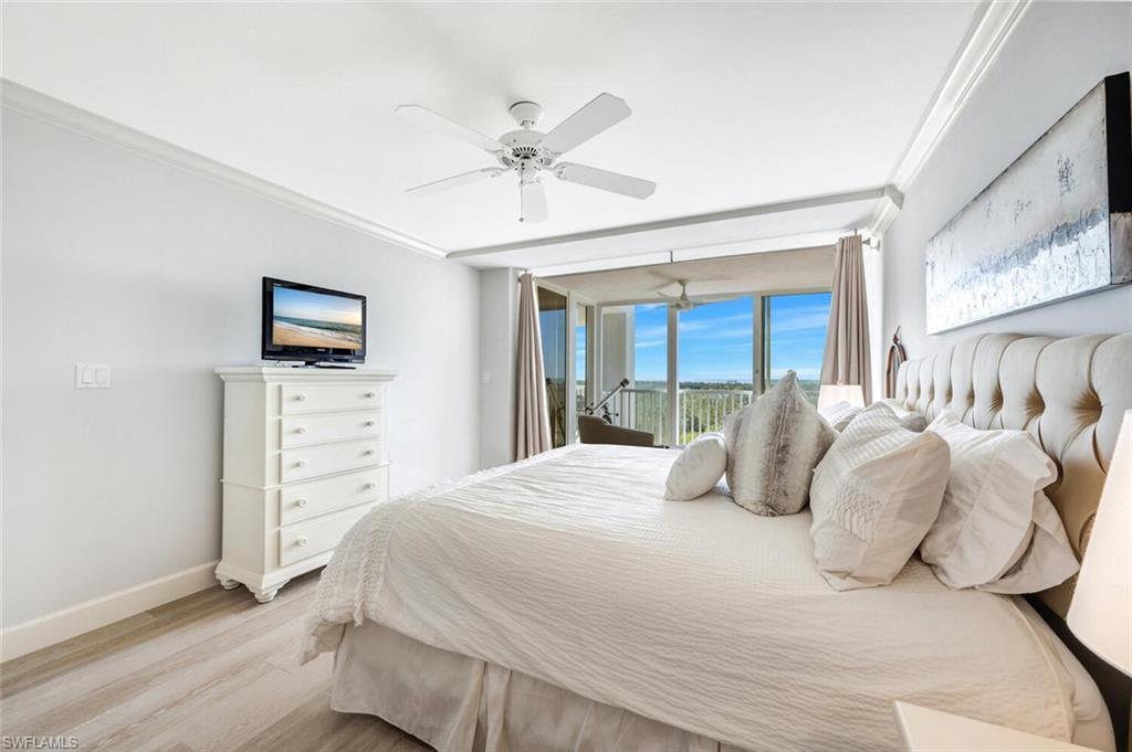 6849 Grenadier Boulevard, Unit 503 Naples, FL 34108 - Photo 16 of 50 a bedroom with a bed and a flat screen tv
