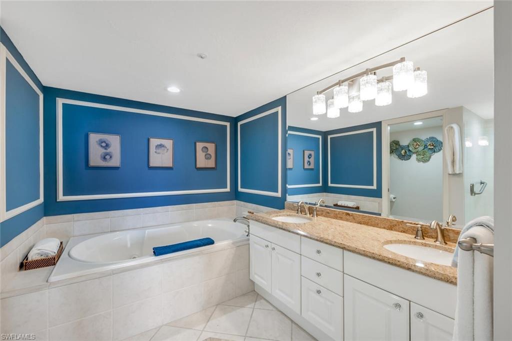 6849 Grenadier Boulevard, Unit 503 Naples, FL 34108 - Photo 21 of 50 a bathroom with a granite countertop tub sink and mirror