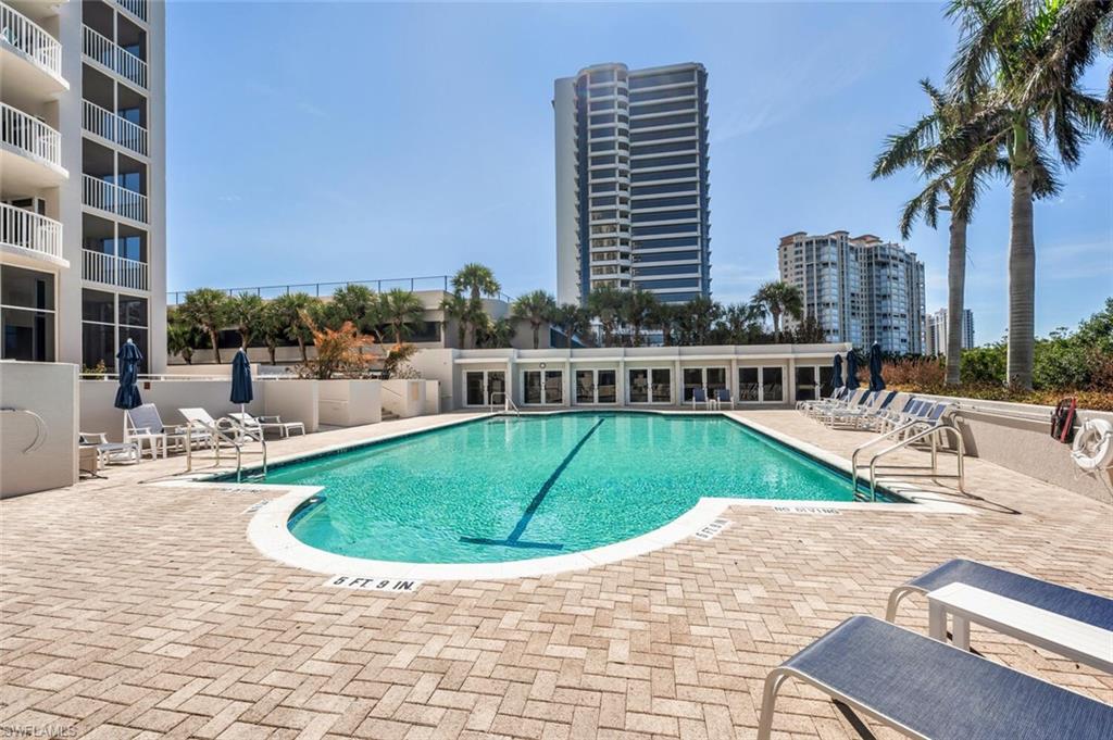 6849 Grenadier Boulevard, Unit 503 Naples, FL 34108 - Photo 34 of 50 a view of a swimming pool with a lounge chair