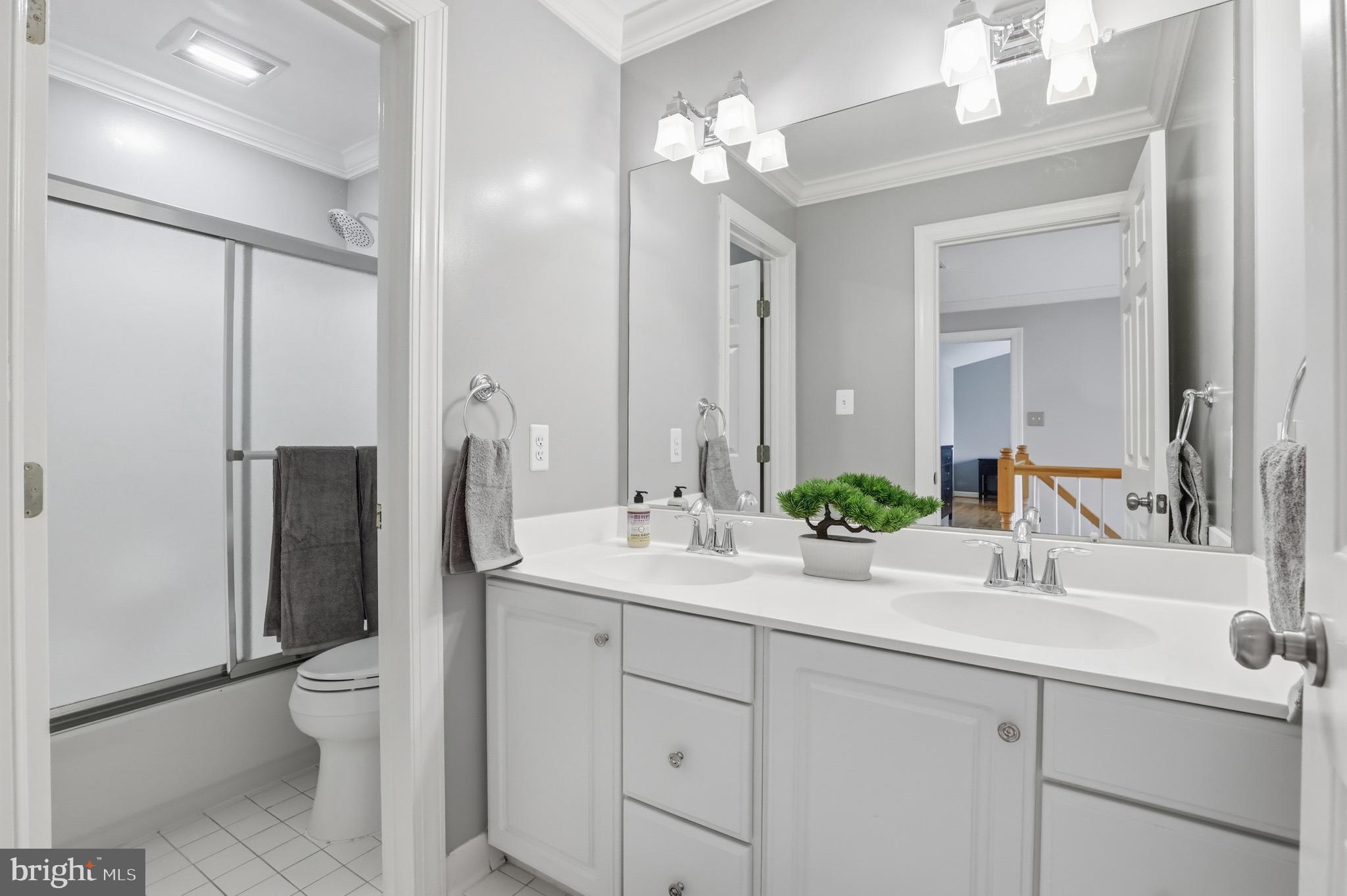 13222 Maplecrest Drive Potomac, MD 20854 - Photo 37 of 61 a bathroom with a double vanity sink toilet and shower