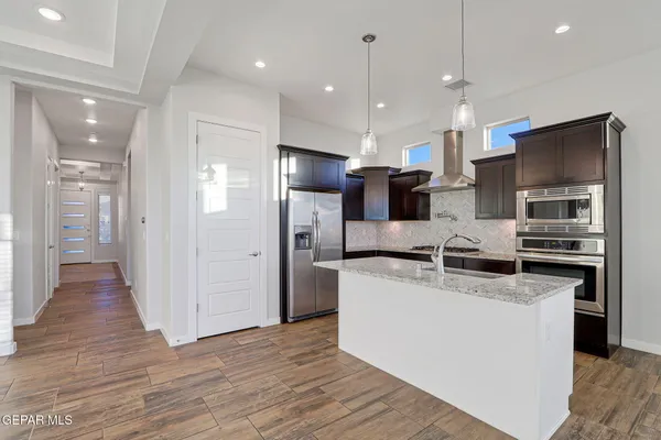 a kitchen with stainless steel appliances granite countertop a sink stove and refrigerator
