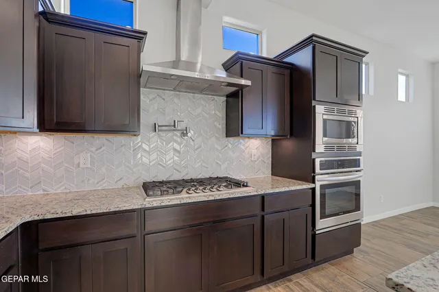 a kitchen with stainless steel appliances granite countertop a sink and a refrigerator