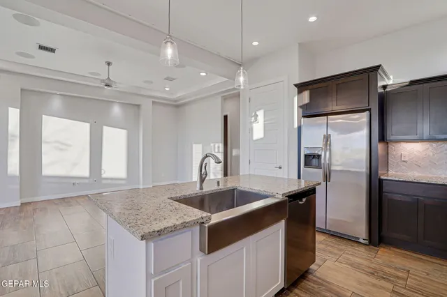 a kitchen with stainless steel appliances granite countertop a sink a stove and a refrigerator