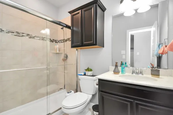 a bathroom with a sink a toilet and shower