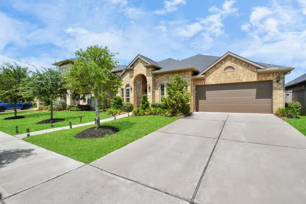 a front view of a house with yard and green space