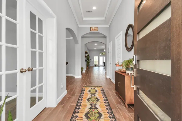 a view of a hallway with wooden floor windows