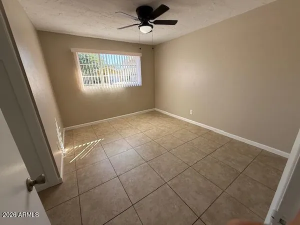 an empty room with windows and fan