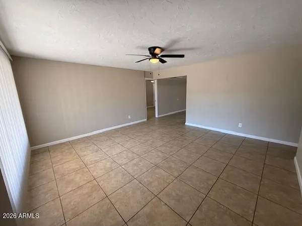 an empty room with a ceiling fan and carpet