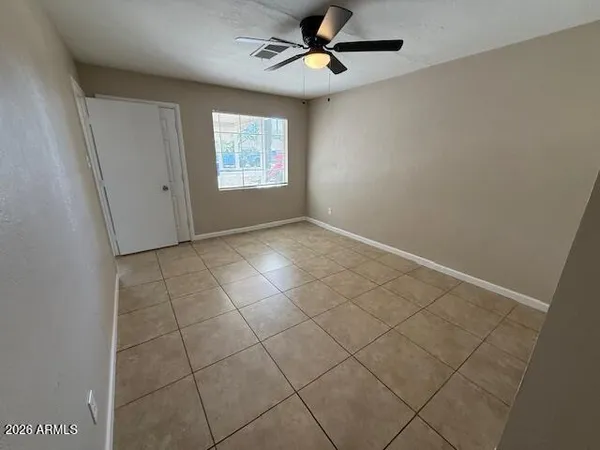 an empty room with windows and fan