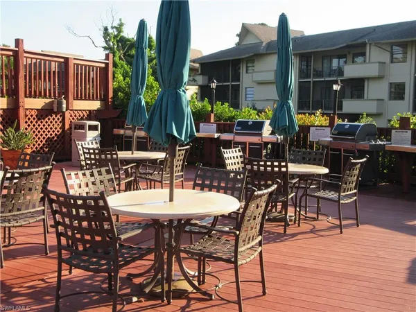 a view of a patio with table and chairs potted plants and wooden floor
