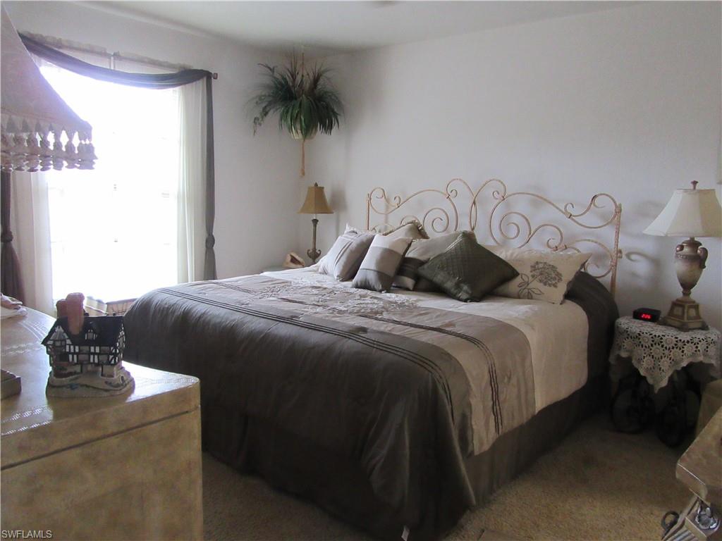 600 Neapolitan Way, Unit 211 Naples, FL 34103 - Photo 5 of 16 a bedroom with a bed and a window