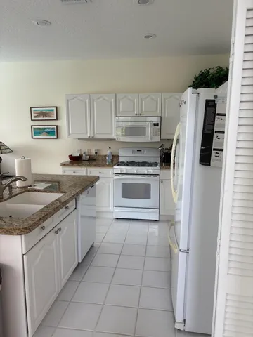 a kitchen with stainless steel appliances a table chairs and a refrigerator