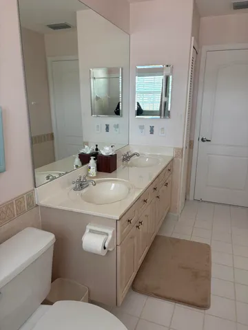 a en suite bathroom with a double vanity sink and a mirror