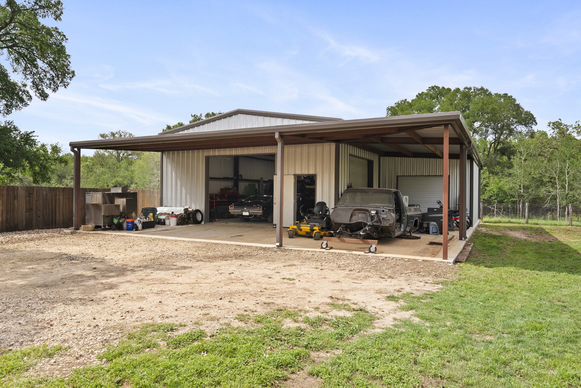 2802 Robin Road Manchaca, TX 78652 - Photo 24 of 40 Metal-sided utility building featuring multiple bays, a covered side extension, and a concrete slab foundation