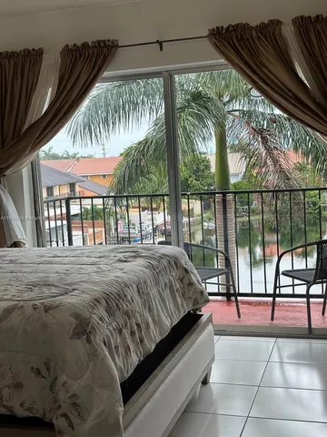 a bed sitting in a balcony next to a window