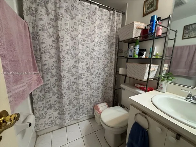 a bathroom with a sink a toilet and shower curtain
