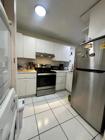 a kitchen with a cabinets and white stainless steel appliances