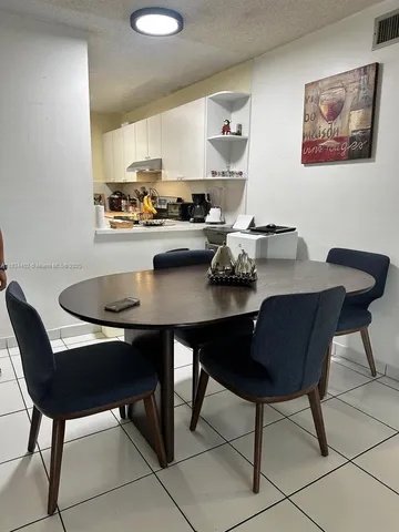 a kitchen with a dining table chairs and cabinets
